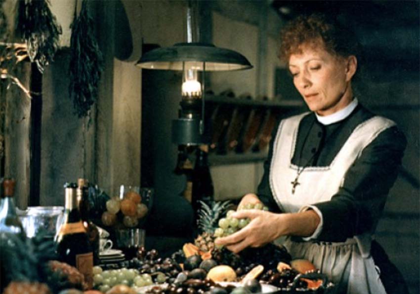 Fotograma. Una mujer delante de una mesa con fruta